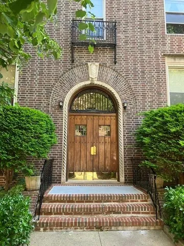 a view of entrance gate of a house with a garden