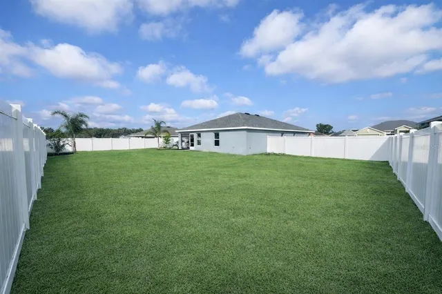 a view of a house with a big yard and a large tree