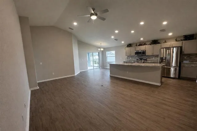 a view of a kitchen with stainless steel appliances a refrigerator and a wooden cabinets