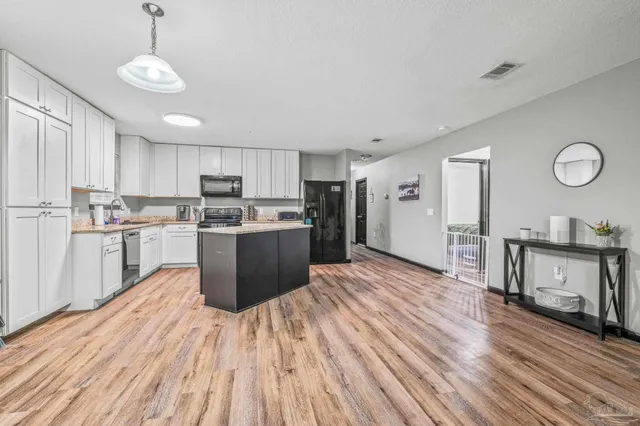 a kitchen with wooden floors and refrigerator