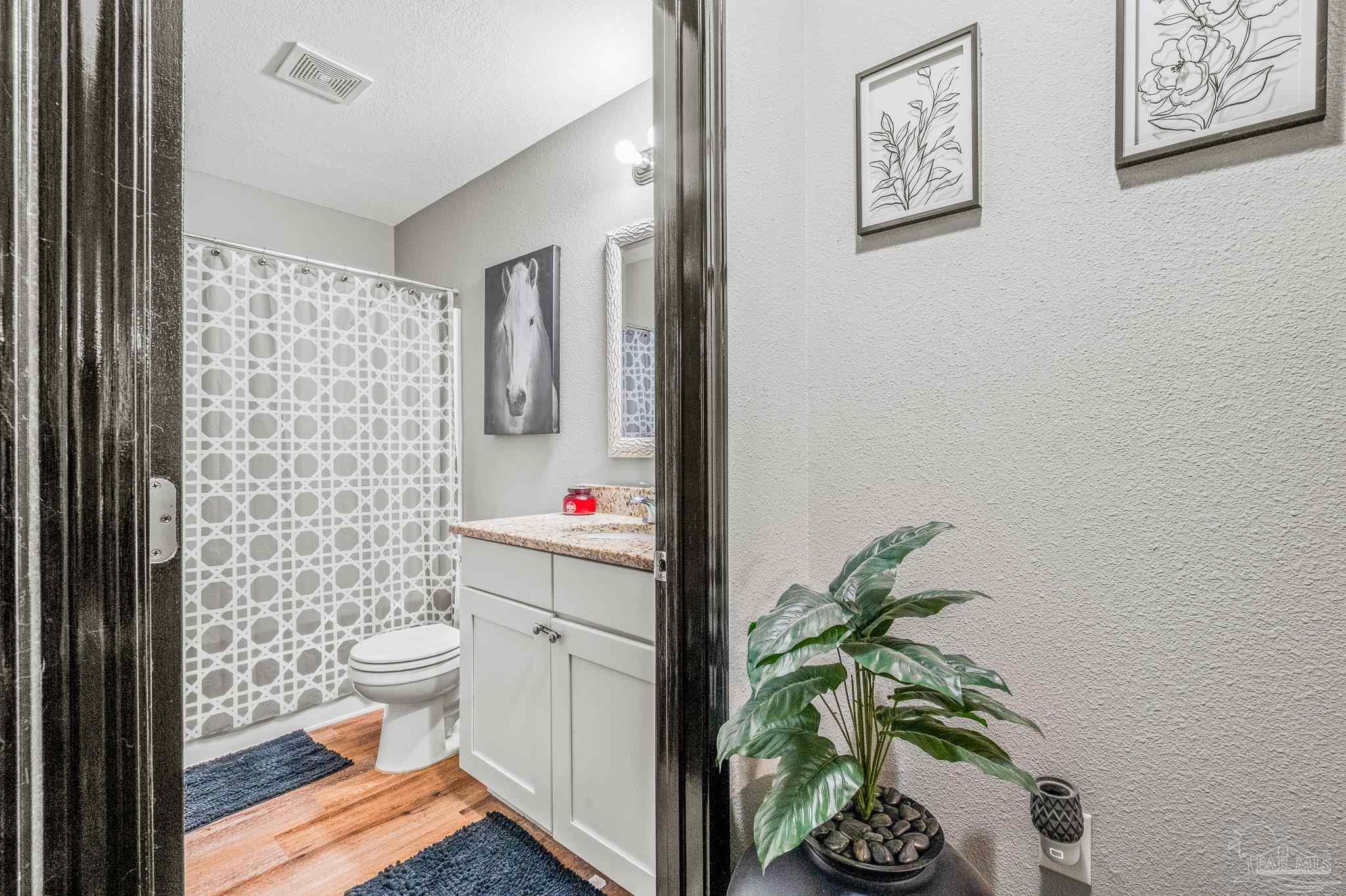 1827 Gainer Avenue Baker, FL 32531 - Photo 18 of 30 a bathroom with a toilet and a shower curtain