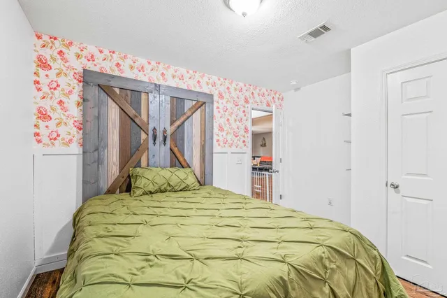 a bedroom with a bed and a painting on the wall