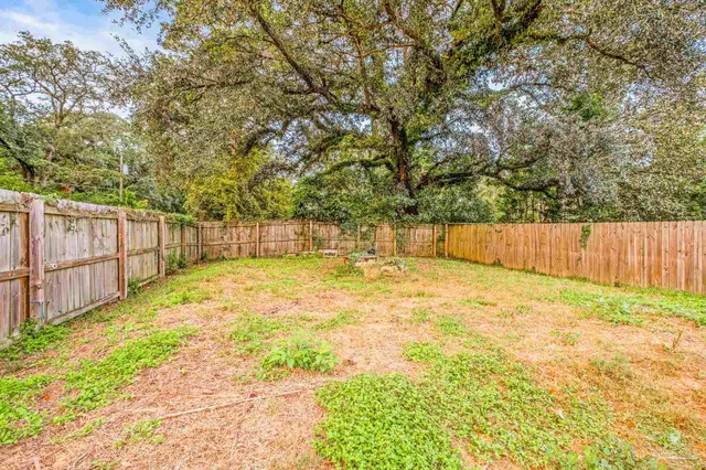 a view of backyard with wooden fence
