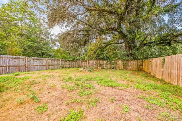 a view of yard with swimming pool and wooden fence