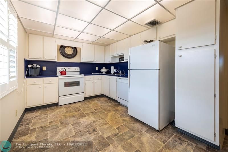 a kitchen with stainless steel appliances a white refrigerator freezer a sink and dishwasher with white cabinets