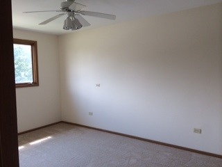 8714 Raintree Road Tinley Park, IL 60487 - Photo 4 of 13 an empty room with a window and a fan