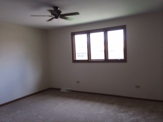 8714 Raintree Road Tinley Park, IL 60487 - Photo 10 of 13 an empty room with a window and a fan