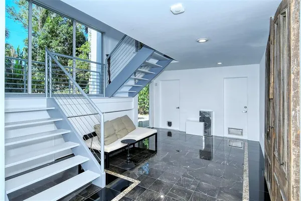 a dining room with furniture and a floor to ceiling window