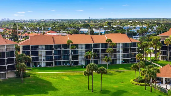 an aerial view of residential houses with outdoor space and trees
