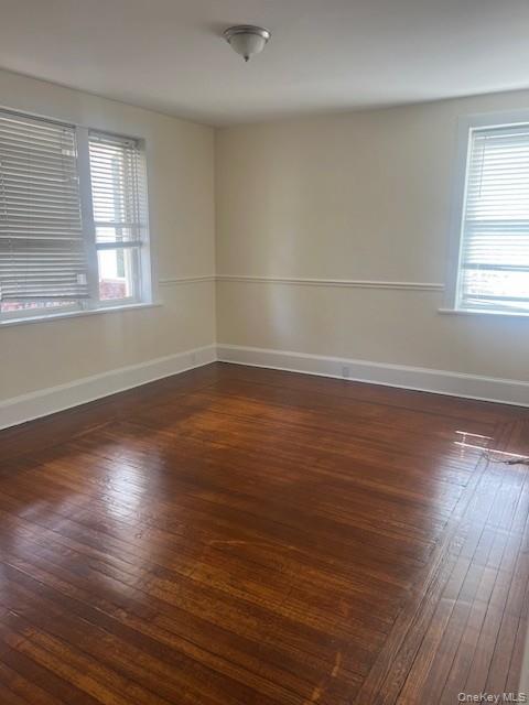 169 Tibbetts Road, Unit 1 Yonkers, NY 10705 - Photo 16 of 17 an empty room with wooden floor and windows