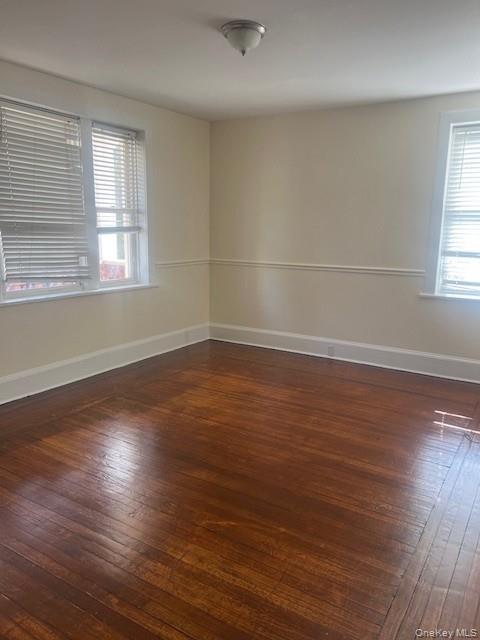 169 Tibbetts Road, Unit 1 Yonkers, NY 10705 - Photo 10 of 17 an empty room with wooden floor and windows with curtains