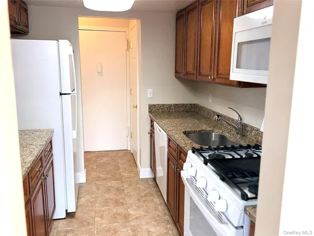 a kitchen with a stove top oven a sink and a refrigerator