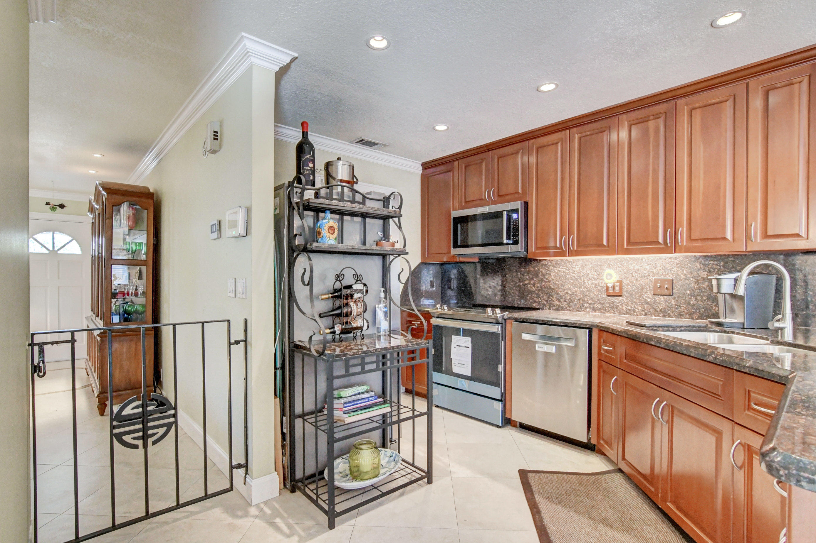 1720 Southwest 9th Street Boca Raton, FL 33486 - Photo 23 of 75 a kitchen with stainless steel appliances granite countertop a refrigerator oven a sink dishwasher and white cabinets with wooden floor