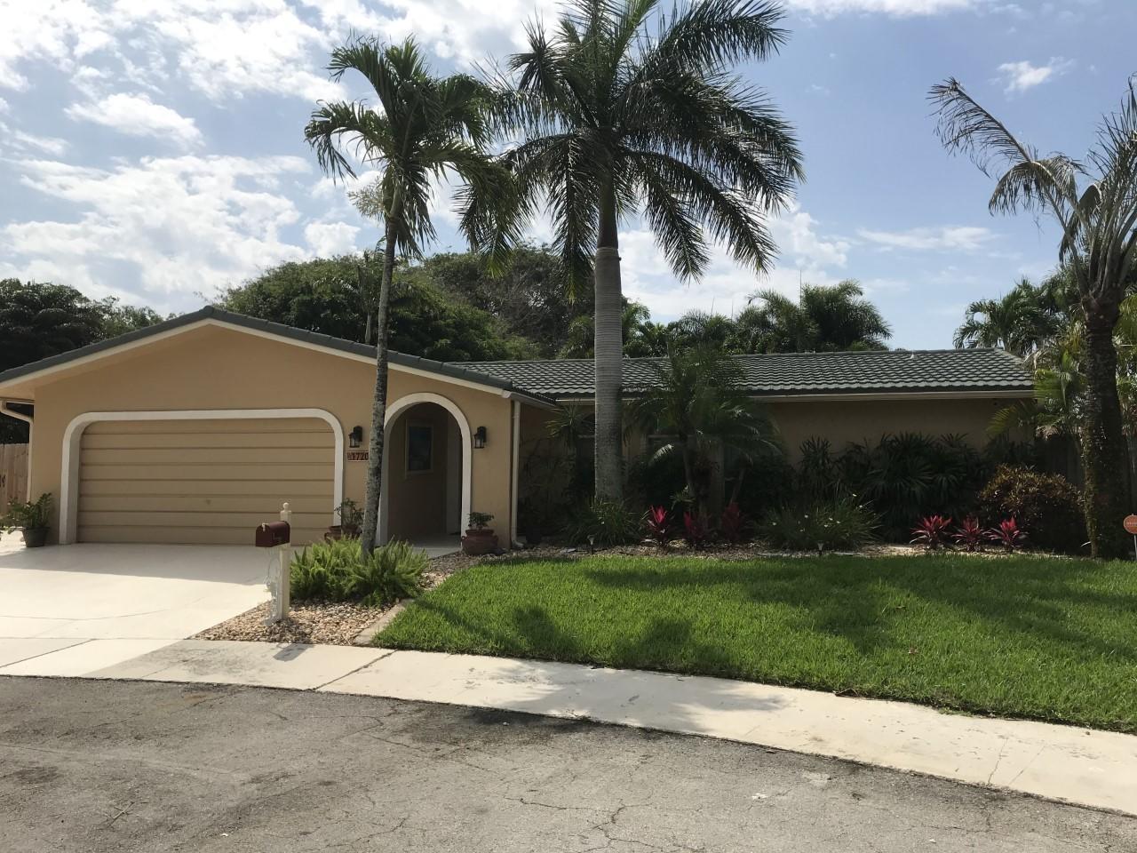 1720 Southwest 9th Street Boca Raton, FL 33486 - Photo 3 of 75 a front view of a house with a garden and trees