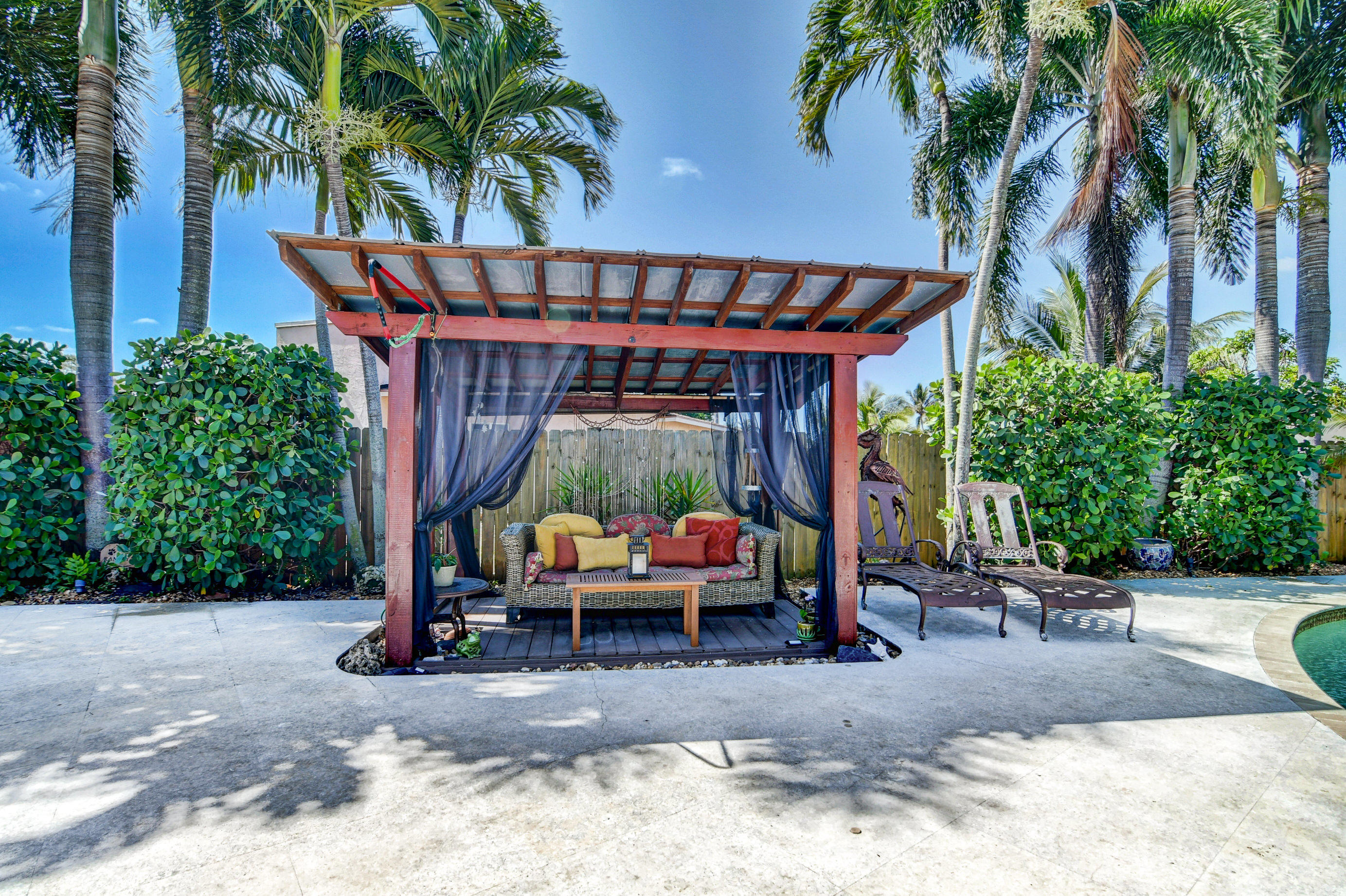 1720 Southwest 9th Street Boca Raton, FL 33486 - Photo 61 of 75 a view of a patio with table and chairs potted plants and palm trees