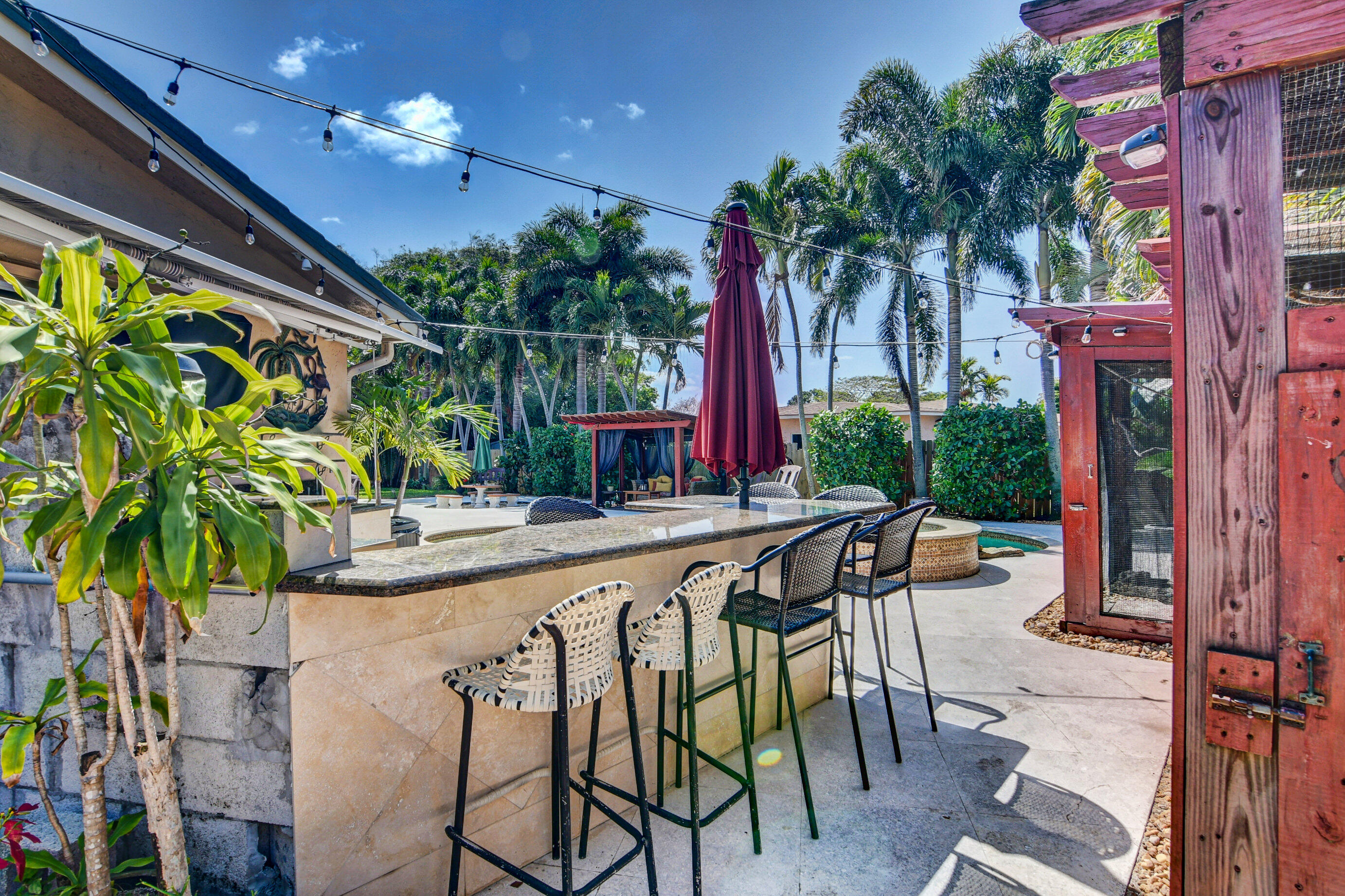 1720 Southwest 9th Street Boca Raton, FL 33486 - Photo 67 of 75 a view of a patio with table and chairs potted plants and palm tree
