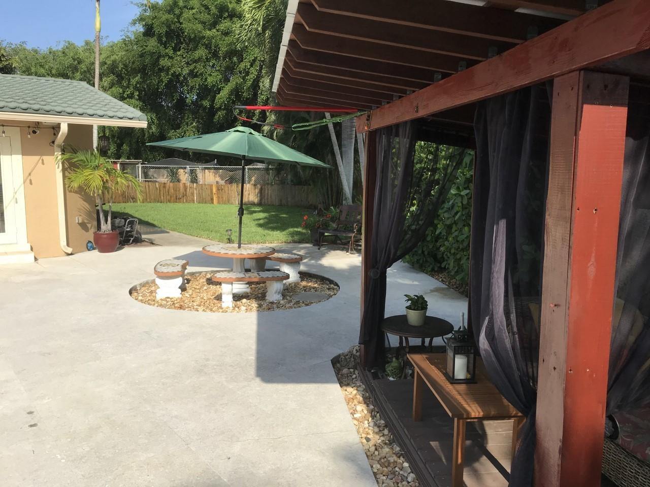1720 Southwest 9th Street Boca Raton, FL 33486 - Photo 73 of 75 a view of a patio with table and chairs under an umbrella