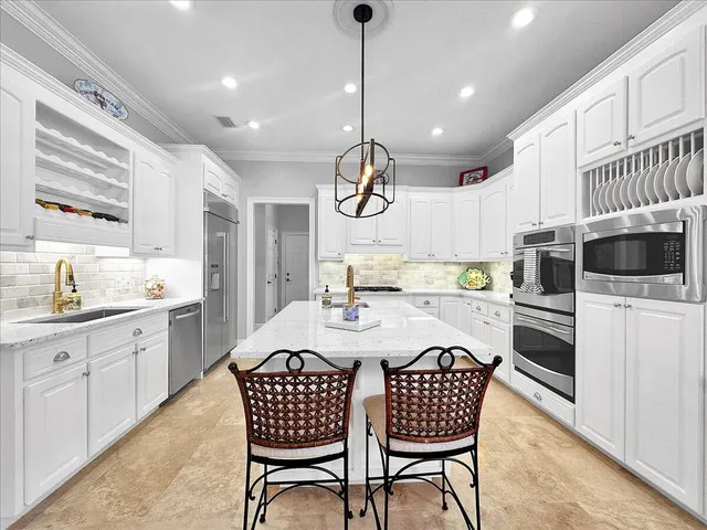 a kitchen with granite countertop white cabinets and stainless steel appliances