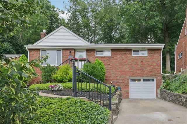 a front view of a house with a yard and potted plants