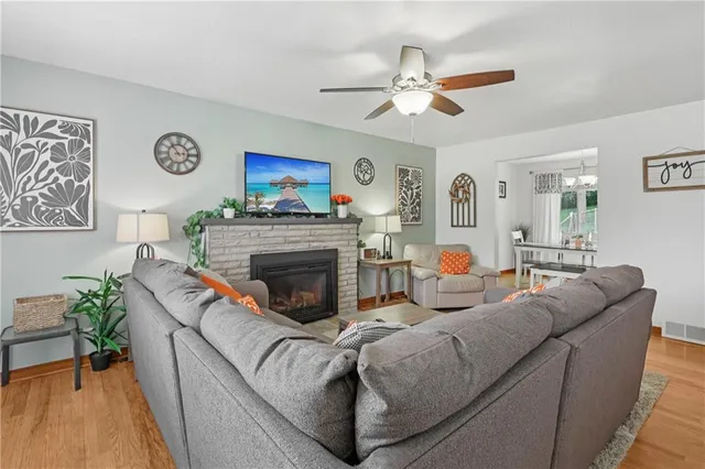 a living room with furniture a clock and a fireplace