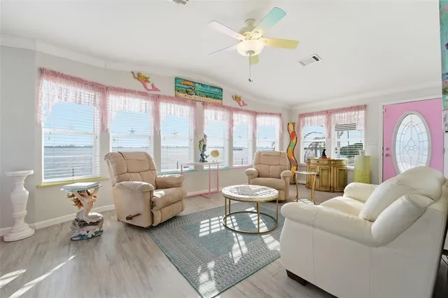 a living room with furniture flat screen tv and a large window