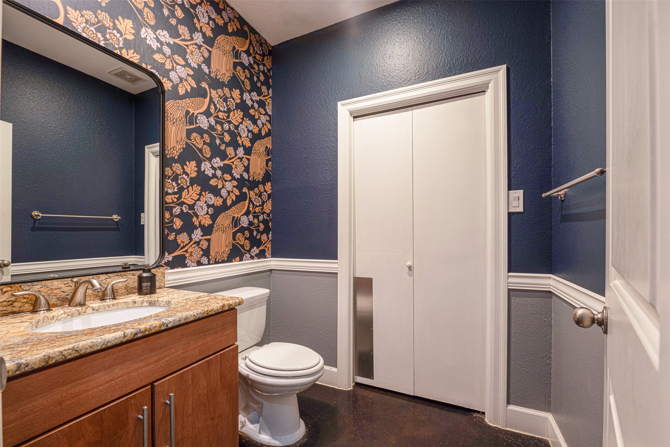 2302 East 9th Street Austin, TX 78702 - Photo 10 of 31 A stylish bathroom showcases a vanity with granite counters and a vibrant peacock-themed accent wall.