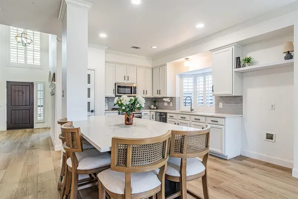 a kitchen with a dining table chairs and refrigerator