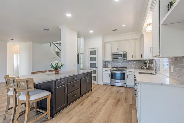 a large kitchen with stainless steel appliances lots of counter space and a sink