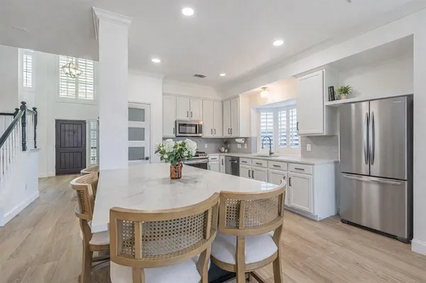 a kitchen with kitchen island a refrigerator a stove a dining table and chairs