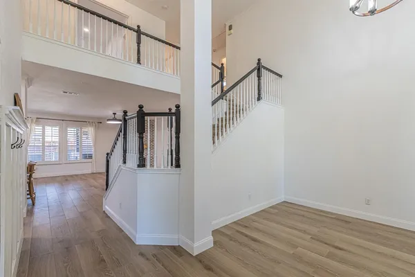 a view of a hallway with wooden floor and staircase