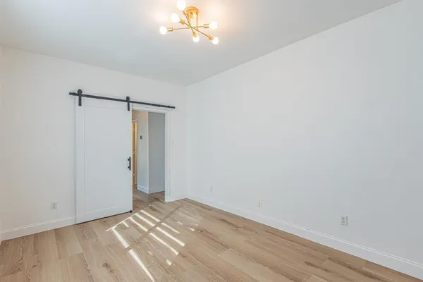 a view of empty room with wooden floor