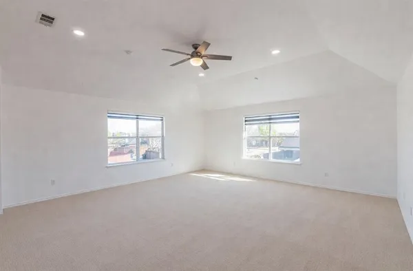 a spacious bedroom with a large bed and windows