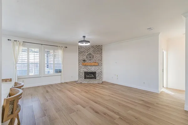 a view of an empty room with a window and fireplace