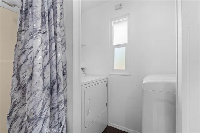 a bathroom with a shower curtain and a window