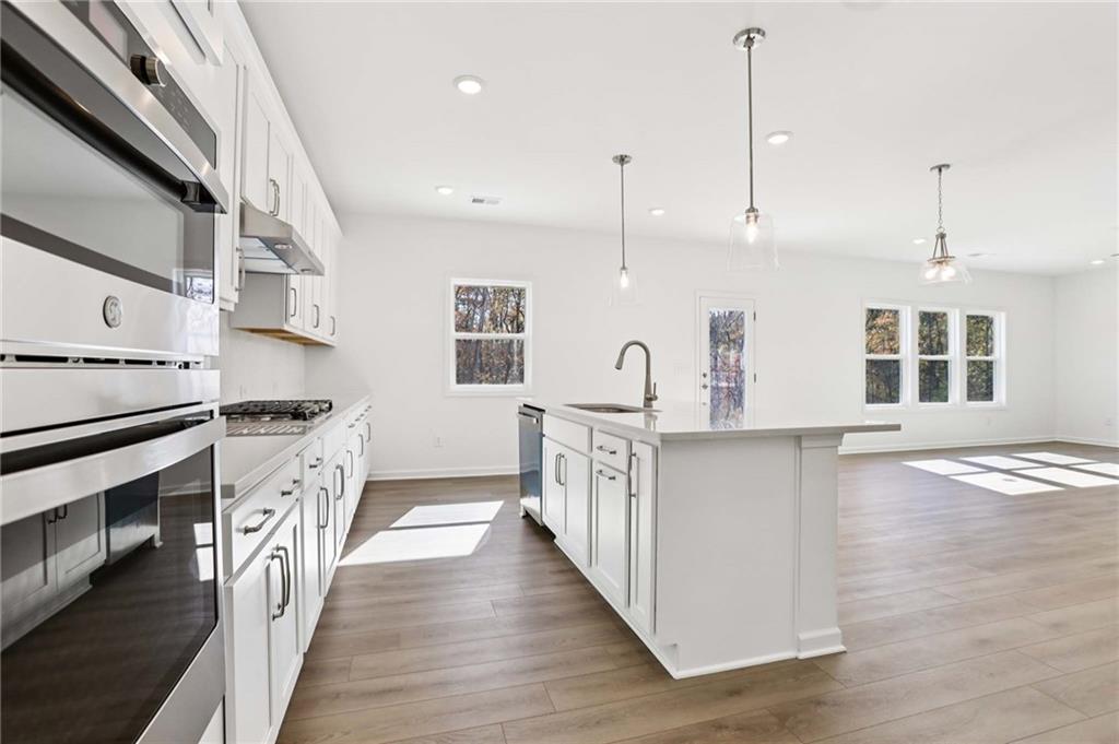 6155 Kismet Road Buford, GA 30518 - Photo 13 of 47 a kitchen with stainless steel appliances granite countertop a stove and a sink