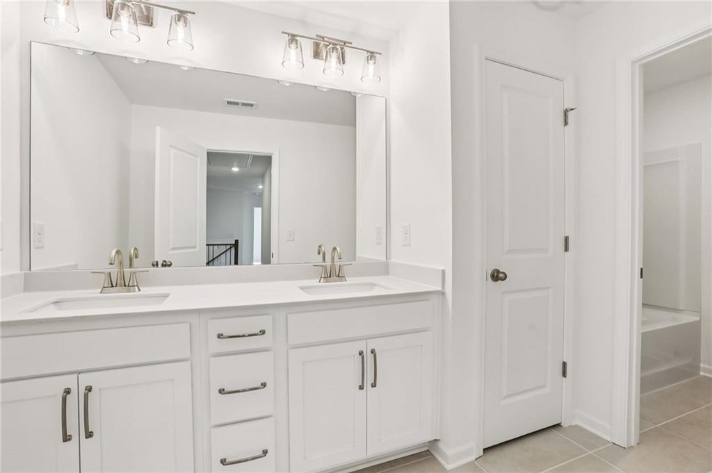 6155 Kismet Road Buford, GA 30518 - Photo 32 of 47 a bathroom with a double vanity sink and mirror