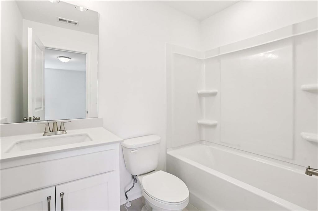 6155 Kismet Road Buford, GA 30518 - Photo 35 of 47 a bathroom with a toilet a sink and a bathtub