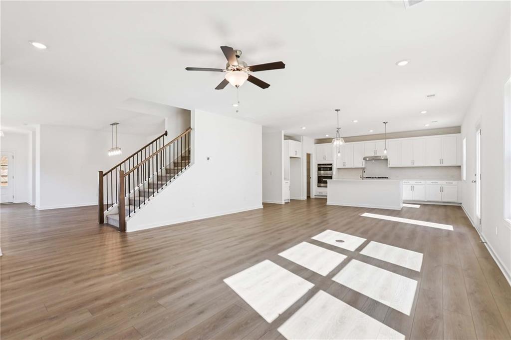 6155 Kismet Road Buford, GA 30518 - Photo 6 of 47 a view of a living room with wooden floor and a kitchen