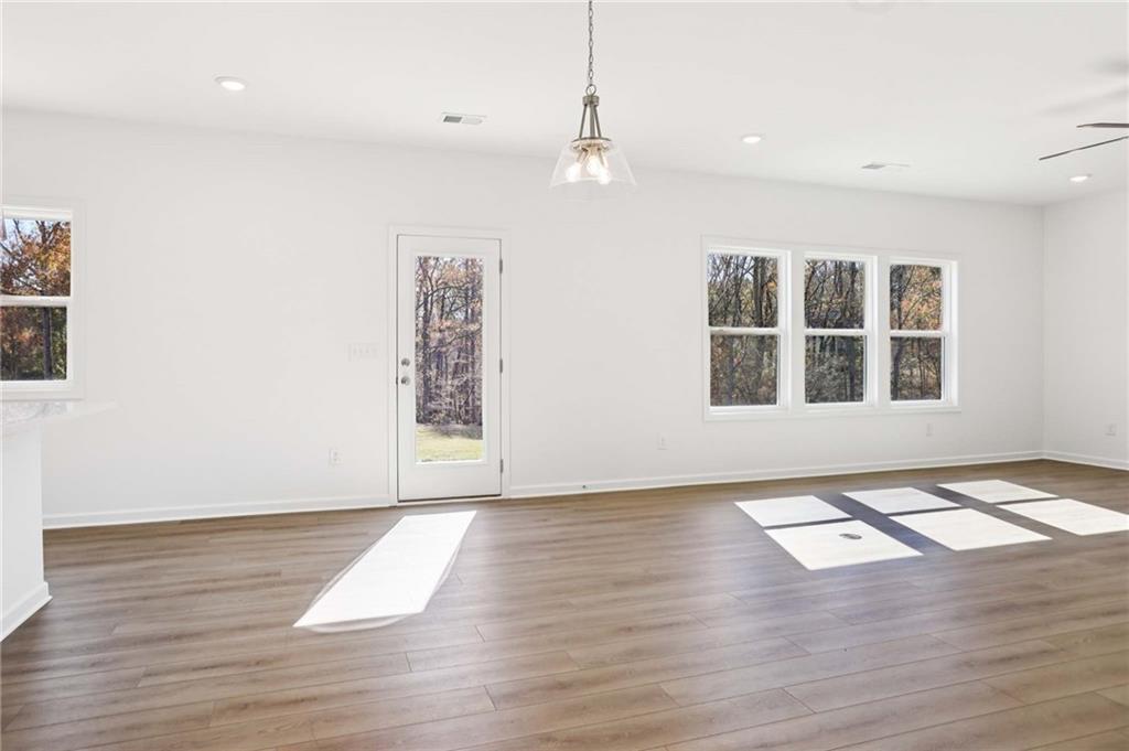 6155 Kismet Road Buford, GA 30518 - Photo 8 of 47 a view of an empty room with wooden floor and a window