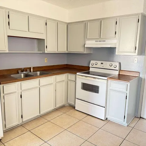 a kitchen with white cabinets and white appliances