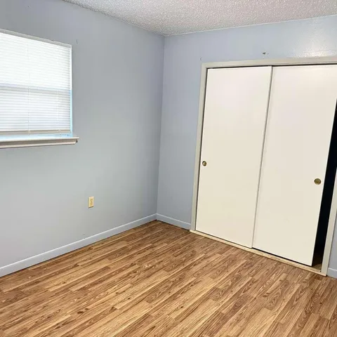 an empty room with wooden floor and a window