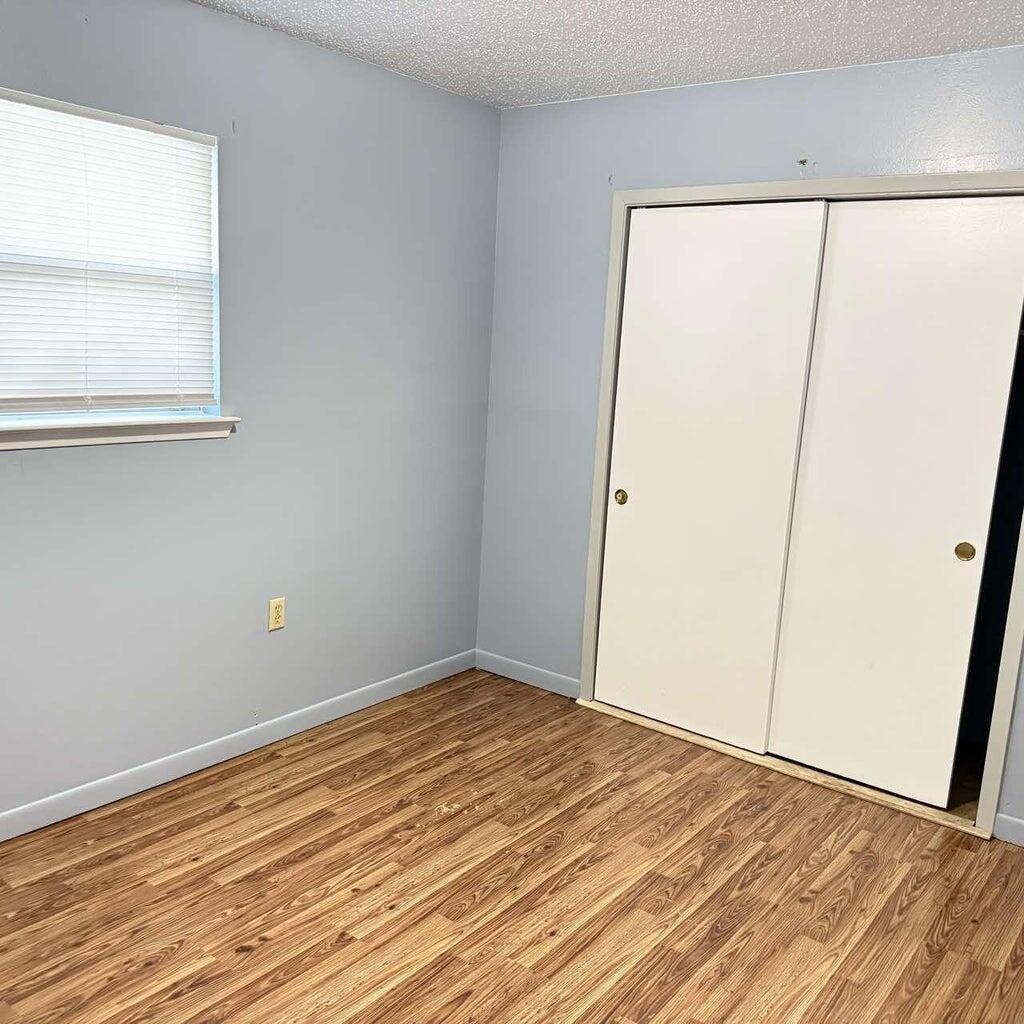 824 Tanager Road, Unit B Fort Walton Beach, FL 32547 - Photo 7 of 9 an empty room with wooden floor and a window