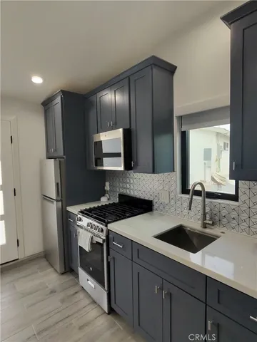 a kitchen that has a sink cabinets and stainless steel appliances