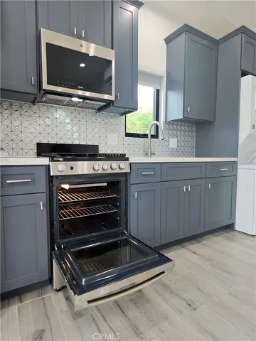 a kitchen with wooden cabinets and a stove top oven
