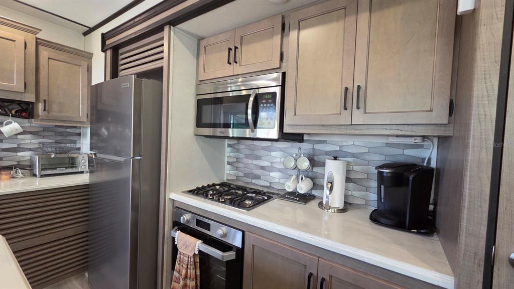 431 Waterway Drive River Ranch, FL 33867 - Photo 17 of 26 a kitchen with stainless steel appliances granite countertop white cabinets a refrigerator and a stove