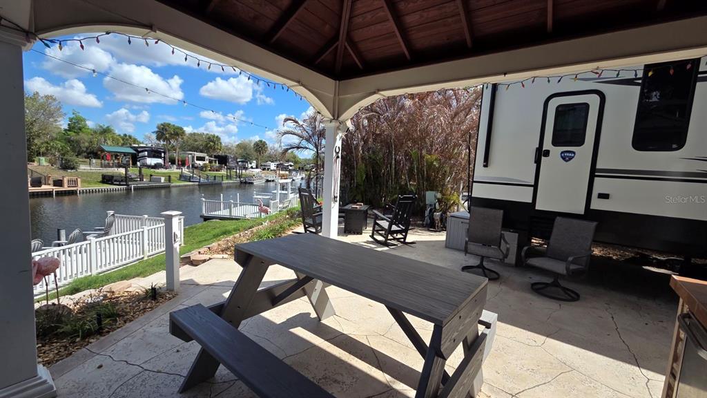 431 Waterway Drive River Ranch, FL 33867 - Photo 7 of 26 a view of a patio with table and chairs with wooden floor and plants