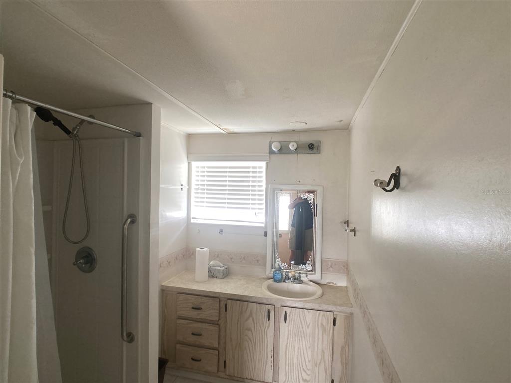 1710 7th Street Southwest, Unit 82 Ruskin, FL 33570 - Photo 13 of 19 a bathroom with a granite countertop sink a toilet and shower