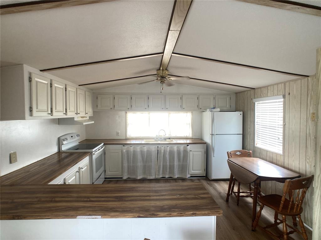 1710 7th Street Southwest, Unit 82 Ruskin, FL 33570 - Photo 6 of 19 a kitchen with kitchen island a table and chairs in it