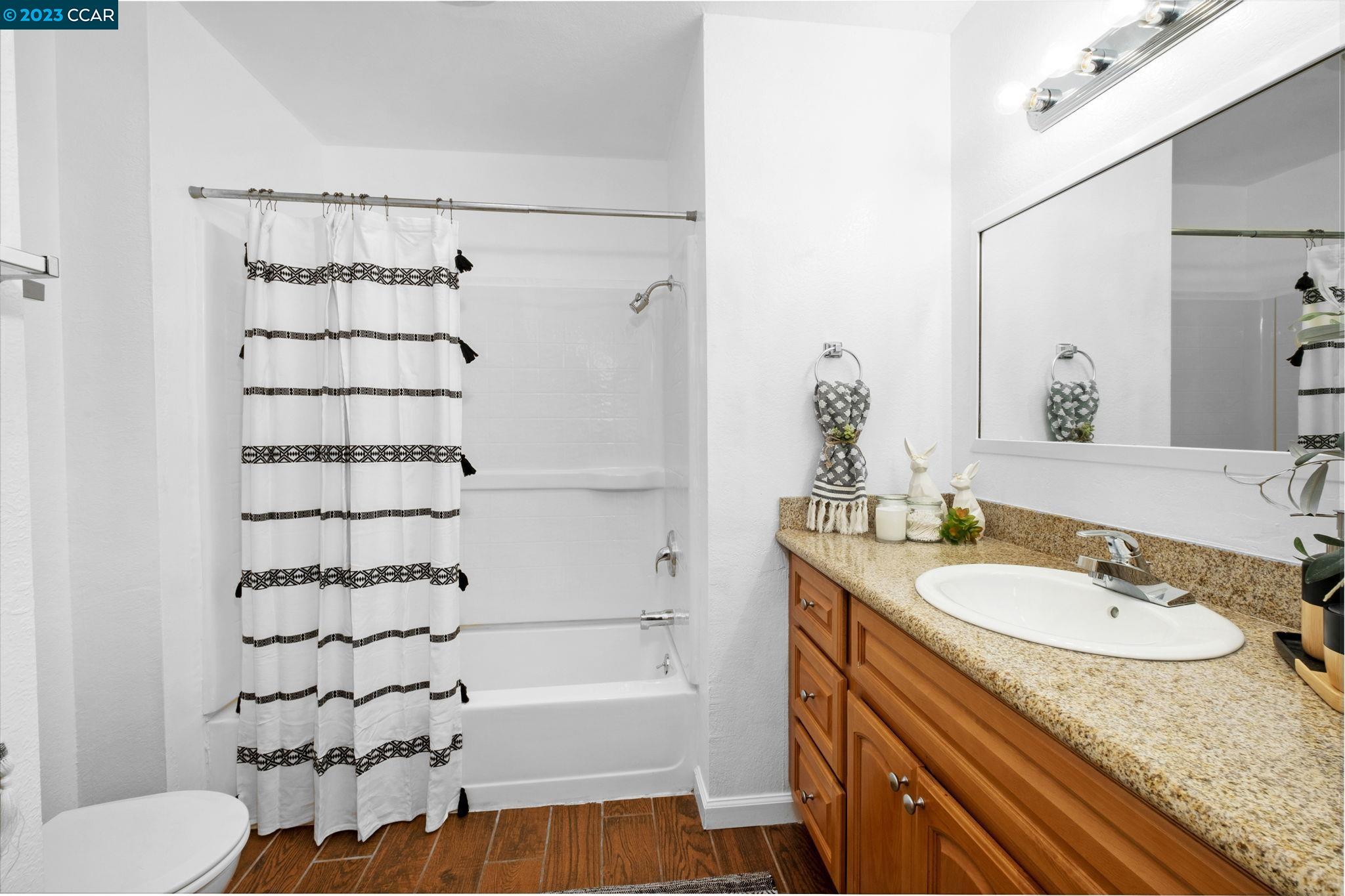 1875 Pomar Way Walnut Creek, CA 94598 - Photo 22 of 32 a bathroom with a granite countertop sink a toilet and shower