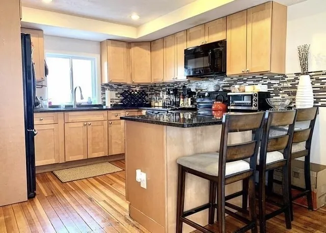 a kitchen with stainless steel appliances granite countertop a stove top oven a sink and cabinets